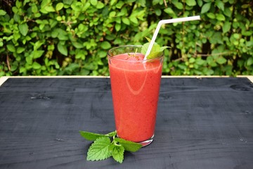 glass of strawberries, peach smoothie with straw on wooden table. Protein cocktail. Healthy drink. Fresh homemade smoothie. Healthy breakfast of smoothie,