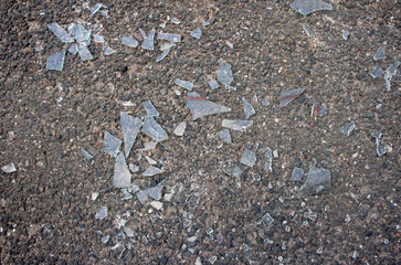 Broken glass on the asphalt background
