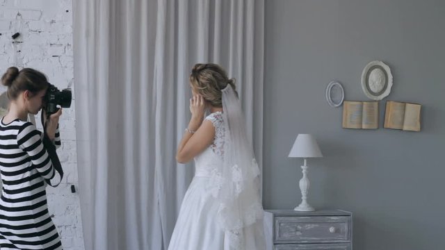 Photographer photographs the bride in a white dress