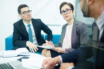 Serious colleagues listening to their employer while planning work
