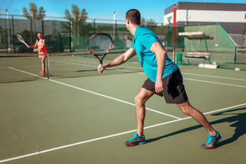 Couple playing tennis on outdoor court