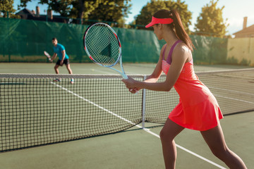 Couple playing tennis on outdoor court