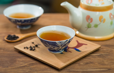 Tea cup and teapot on wooden table , close-up.