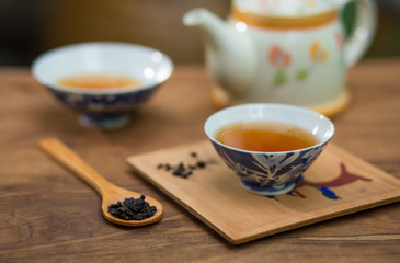 Tea cup and teapot on wooden table , close-up.
