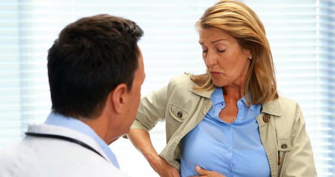 Patient suffering from stomach ache while consulting doctor