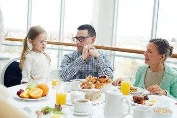Obraz na płótnie Canvas Cute girl, her father and grandmother having breakfast