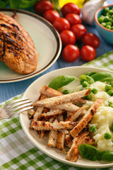 Grilled turkey fillet with mashed potatoes and green peas.