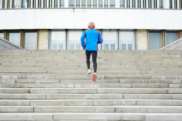 Young man running upstairs in urban environment