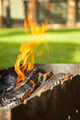 Burning coals in the grill. Charcoal barbecue blazing and growing in tray. BBQ