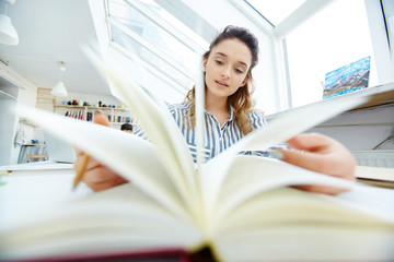 Curious teenager looking through interesting book