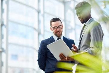 Fototapeta premium Confident banker listening to his colleague explanation of data