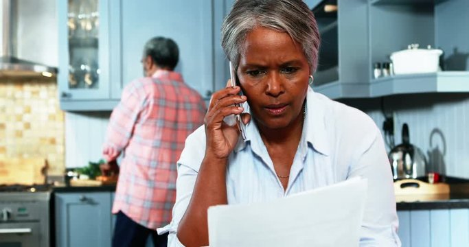 Senior woman talking on mobile phone in kitchen