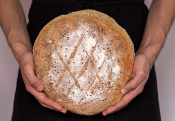 Baker holding bread.