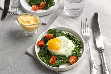 Delicious eggs Florentine with tomatoes on kitchen table