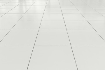 White tile floor background in perspective view. Clean, shiny, symmetry with grid line texture. For...