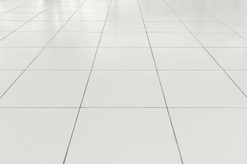 White tile floor background in perspective view. Clean, shiny, symmetry with grid line texture. For...