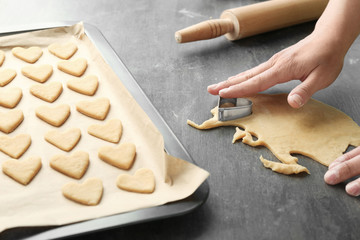 Woman preparing butter cookies on table