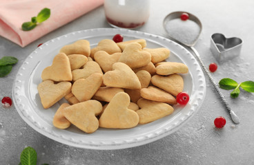 Plate with heart shaped butter cookies on table
