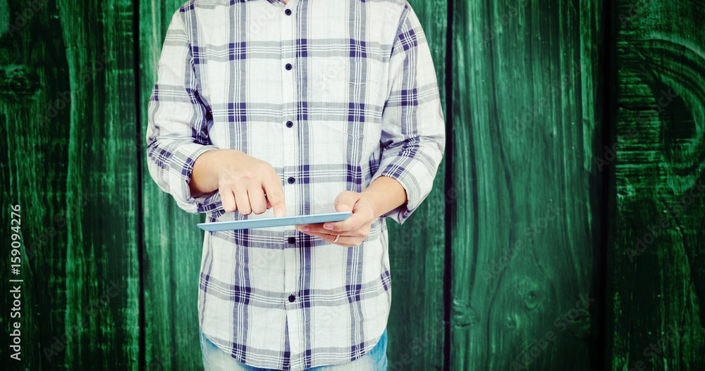 Poster composite image of mid section of man using digital tablet
