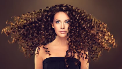 Photo sur Plexiglas Salon de coiffure Fille brune aux cheveux ondulés longs et brillants. Beau modèle avec une coiffure frisée.