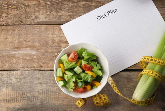 Diet plan, healthy foods and measuring tape on wooden background