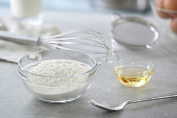 Glass bowl with wheat flour on kitchen table