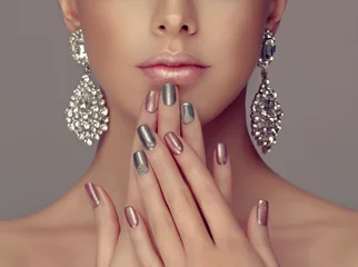Foto op Aluminium Mooi model meisje met roze en grijs zilver metallic manicure op nagels. Mode make-up en cosmetica. Grote zilveren diamanten glans oorbellen sieraden. © Sofia Zhuravetc