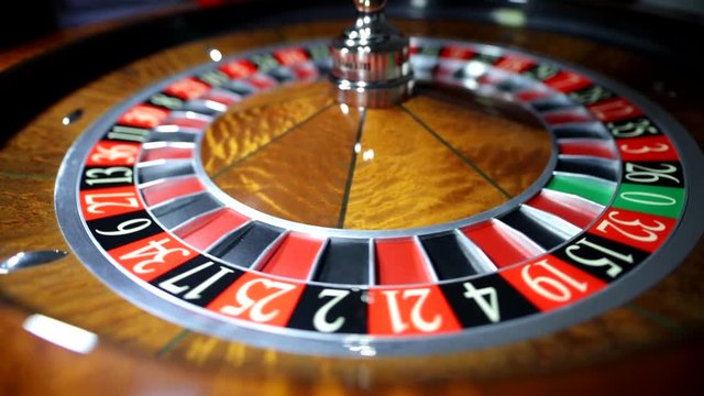 Croupier is spinning the ball. American Roulette wheel.