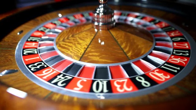 Croupier is spinning the ball. American Roulette wheel.