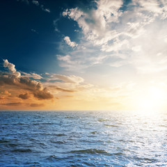 dark sea and sunset in cloudy sky