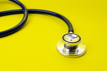 stethoscope on yellow background, heart health care and medical technology concept, selective focus, copy space