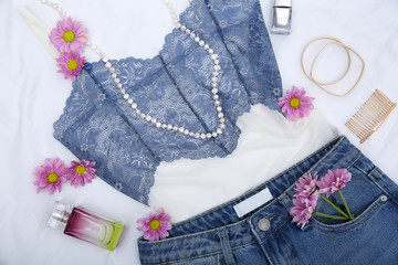 Composition with trendy female clothing, accessories and lilac flowers on white background