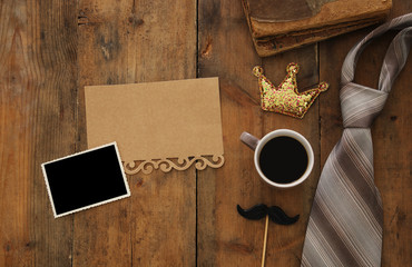 old books, glitter crown, necktie and cup of coffee. Father's day concept