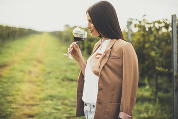 Young woman tasting wine in the vineyard