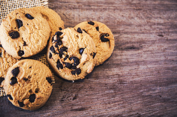 Obraz na płótnie Canvas Chocolate chip cookies on old wooden table