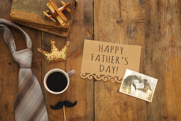 old books, glitter crown, necktie and cup of coffee. Father's day concept