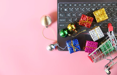 Gift Box in trolley on a laptop,Concept Birthday party gift, Ideas about online shopping, seller over the internet.Copy space,minimal style