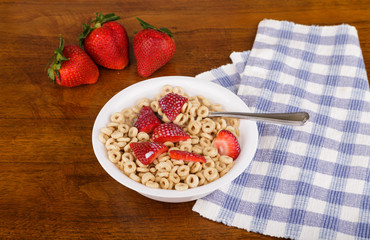Spoon in Fresh Strawberries on Oat Cereal with Milk