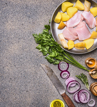 turkey breast with pears and potatoes on a vintage pan with red onion and herbs with a knife for meat and various spices on a granite background, Border, place for text