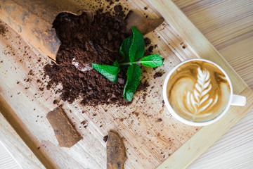 Close-up on a wooden board, trendy, tasty, chocolate dessert with ice cream, decorated with mint, beautiful stylish serve, cappuccino, restaurant, top view
