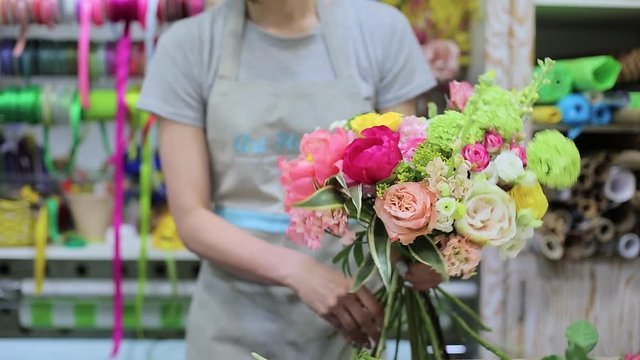 Female florist Arranging Flowers In Flower Shop