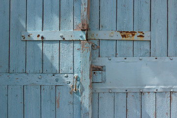 blue wooden gate with strips from metal