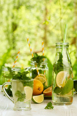 Fresh summer drinks in glassware on white wooden table