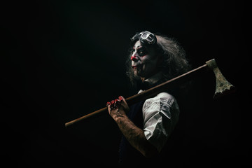 Portrait d'un clown sadique, une hache ensanglanté sur son épaule
