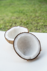 Closeup of coconuts on the white isolated over blurred grass background