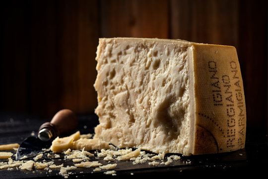 Slice of parmesan cheese with wooden background