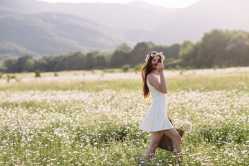 Woman enjoying daisy field, nice female lying down in meadow of flowers, pretty girl relaxing outdoor, having fun, holding plant, happy young lady and spring green nature, harmony concept