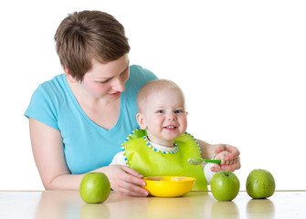 mother feeding kid boy with spoon isolated on white