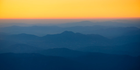 Orange sunset in the mountains. View from a height.
