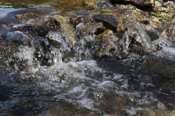 Stream flowing over stones rough rocks